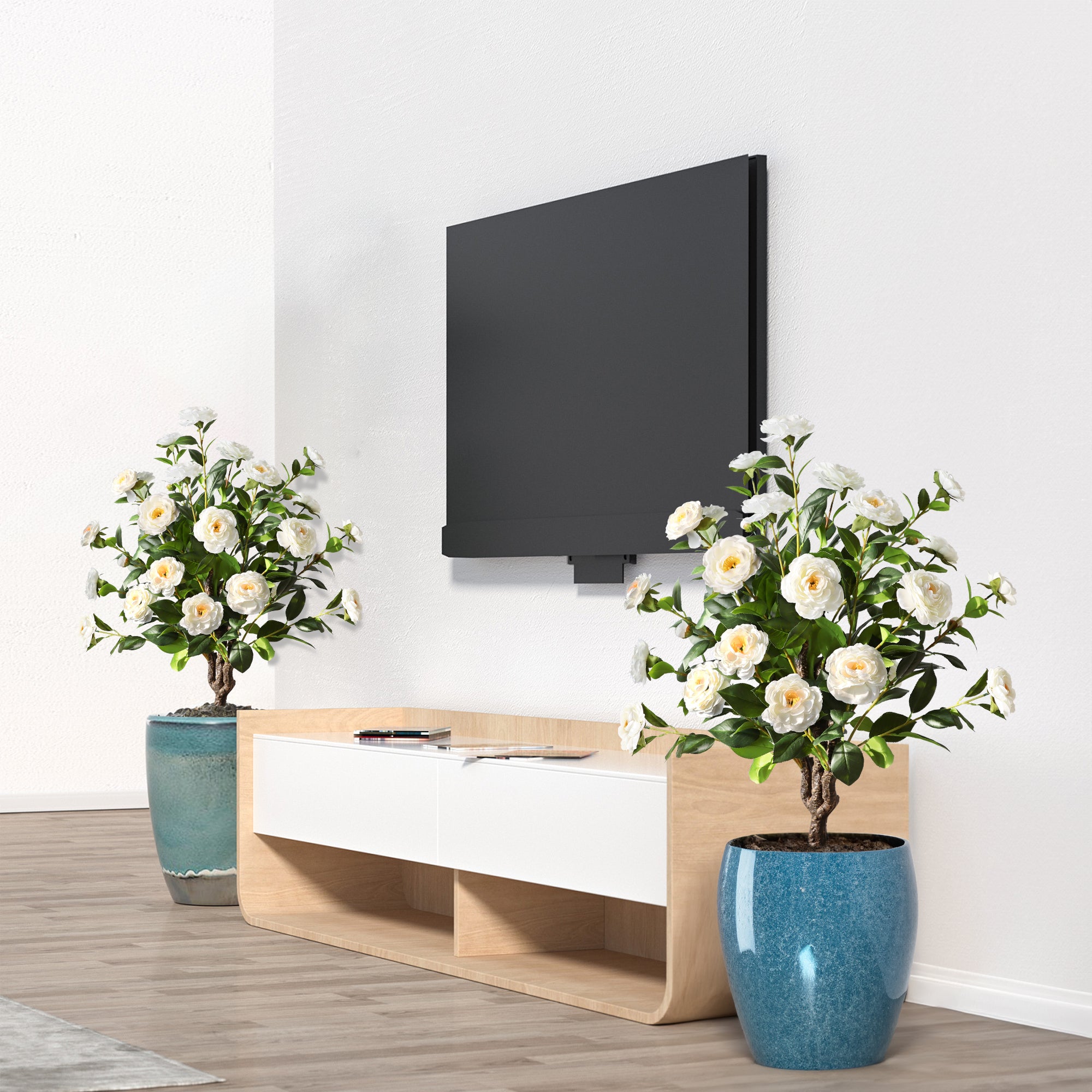two white camellia spike trees in living room corners adding elegant pure white color to neutral decor