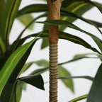 tall artificial dracaena plant in minimalist white room with modern furniture adding organic shape and green accent