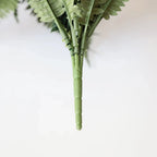 two faux boston fern plants placed on tall bookshelf with fronds cascading over edges adding greenery to home library
