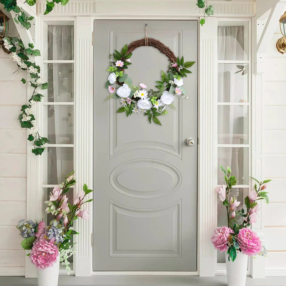 close up of artificial white roses on spring wreath showing layered petals, cream center, and subtle green leaves