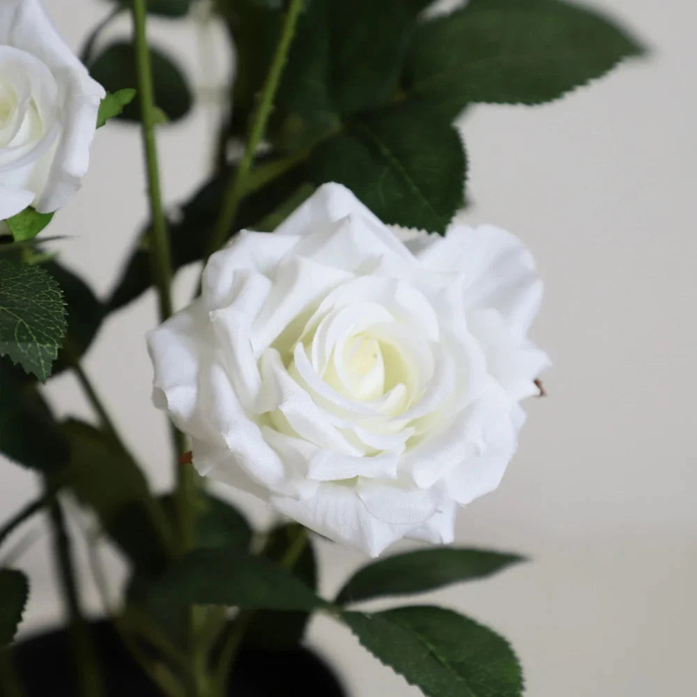 close up of artificial white rose with layered petals, cream center, and subtle gradient from pure white to ivory