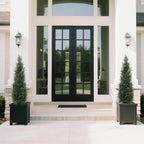 set of 2 artificial topiary cedar trees on covered porch steps for traditional southern or colonial style entry