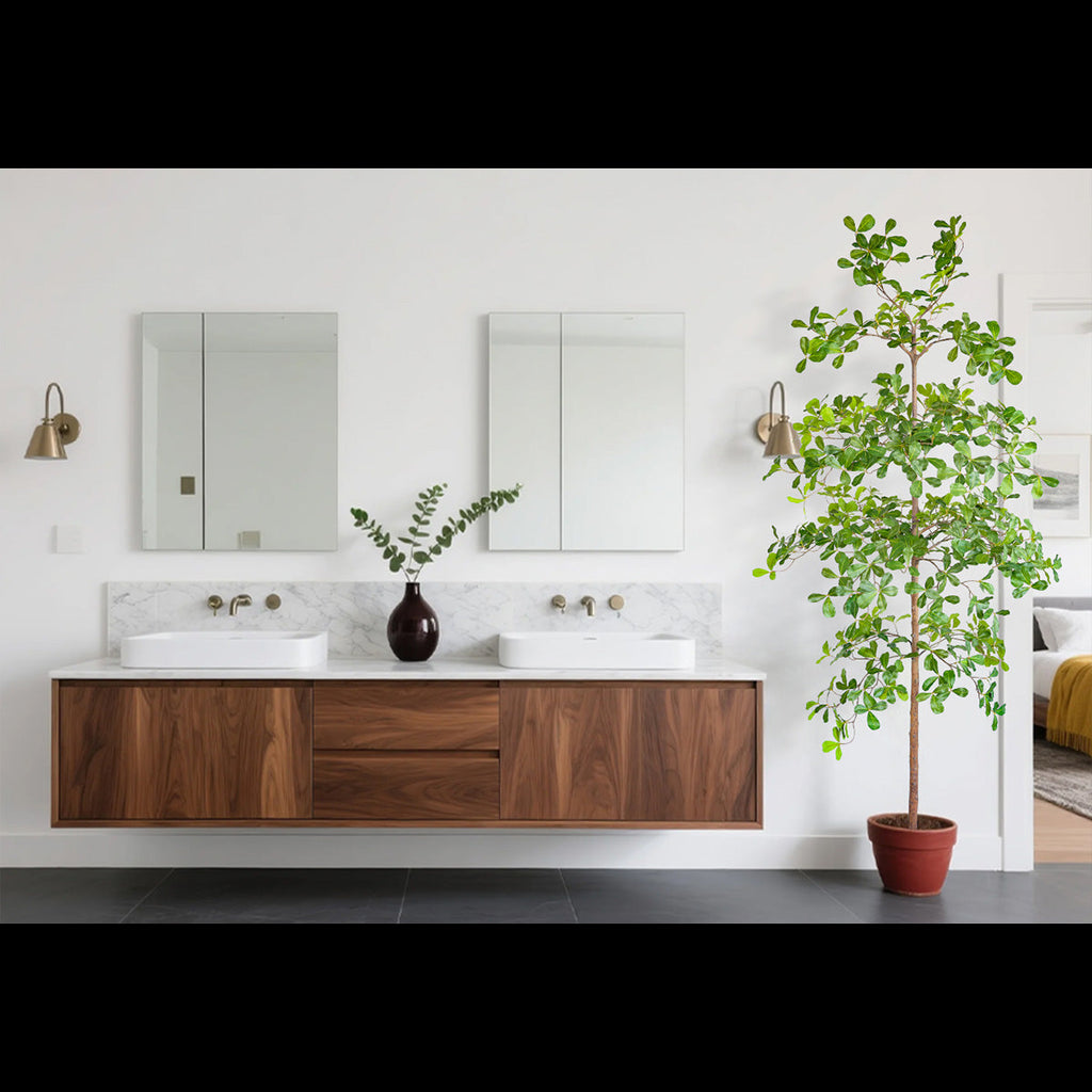 tall artificial olive tree standing in two-story foyer entrance next to staircase demonstrating grand scale