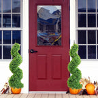 set of 2 elegant spiral topiary trees on covered porch steps for refined traditional style entry