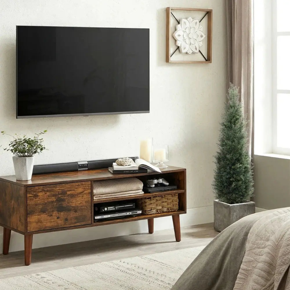 two tall faux cedar topiary trees on each side of fireplace mantel adding year round greenery to living room