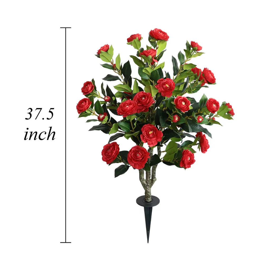 two artificial red camellia plants placed in living room corners adding vibrant color to neutral decor